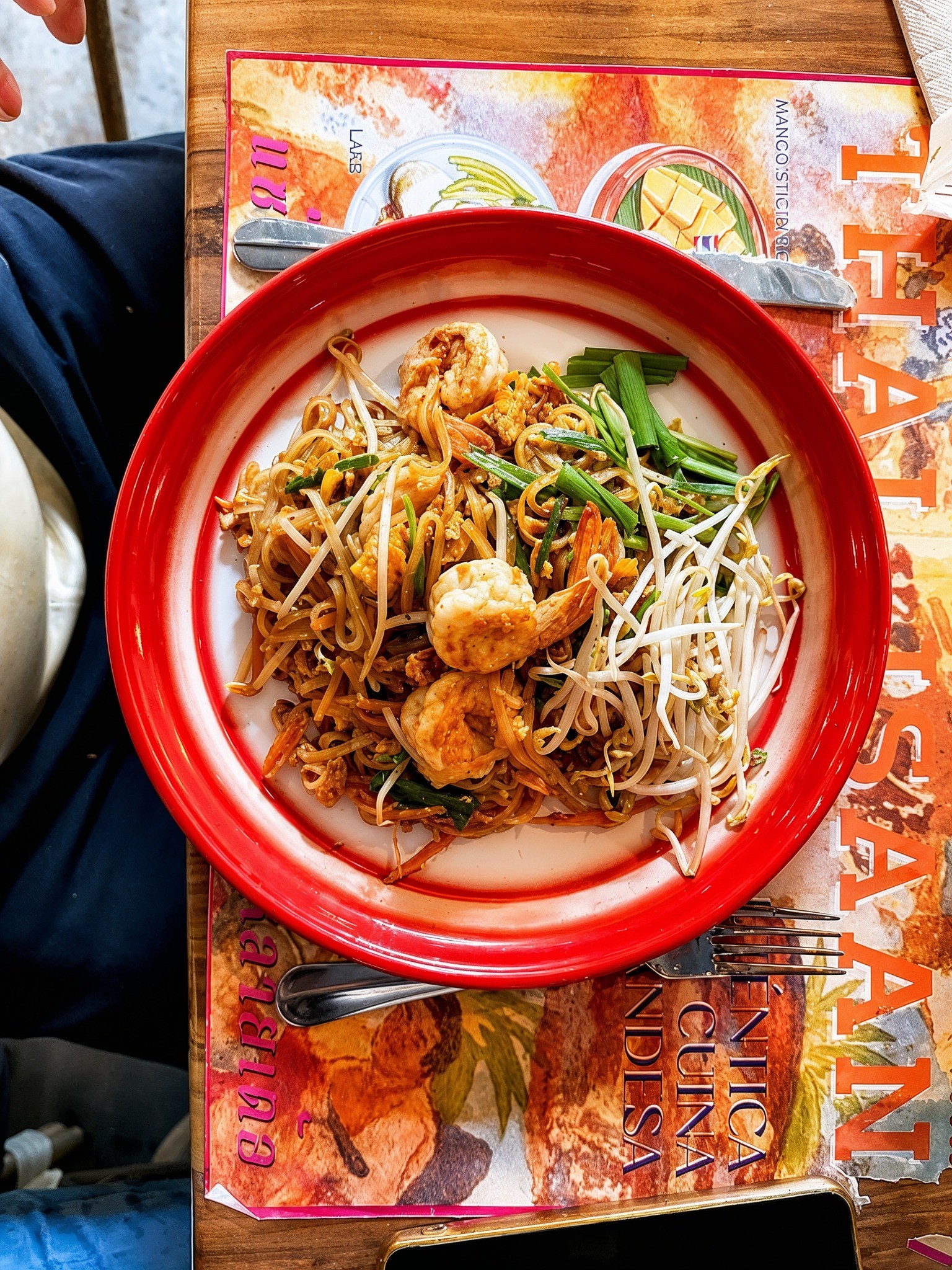 Pad Thai served on a red-rimmed plate at THAI ISAAN